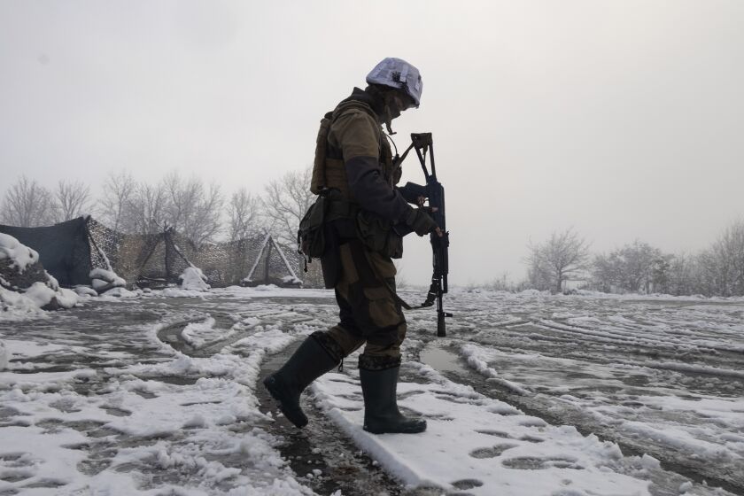 FILE - A Ukrainian soldier walks at the line of separation from pro-Russian rebels near Popasna, Donetsk region, Ukraine, Tuesday, Dec 7, 2021. When Russia annexed Ukraine's Crimean Peninsula in 2014 and threw its support behind separatists in the country's east, Kyiv's underfunded and disorganized armed forces struggled to respond. Now, amid fears that a Russian troop buildup near Ukraine's border could signal a possible attack, military experts say there would be stronger resistance but that Ukraine would be well short of what it needs to counter Russia's overwhelming land, sea and air superiority. (AP Photo/Andriy Dubchak, File)