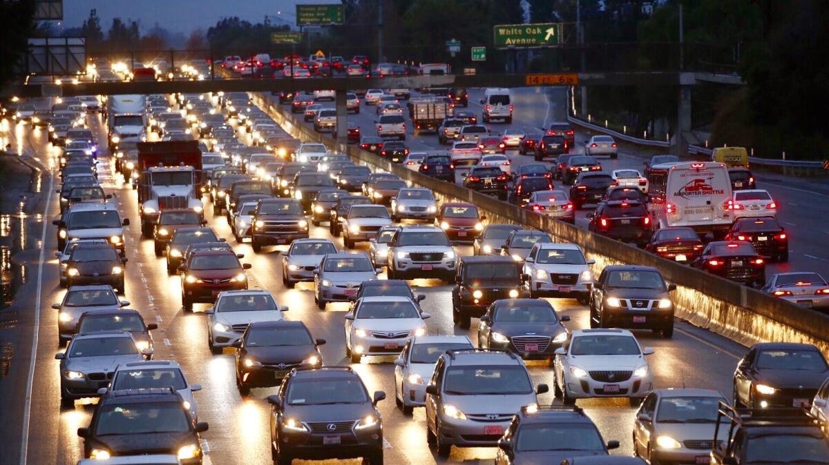 Los Angeles traffic moves at a crawl on the 101 Freeway at White Oak in the San Fernando Valley on Jan. 9, as morning commute drivers navigate rain-slick roads after an overnight storm.