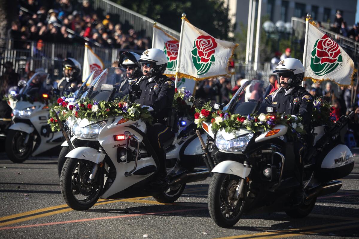 Pasadena police on motorcycles clear the roads on the Rose Bowl Parade route.