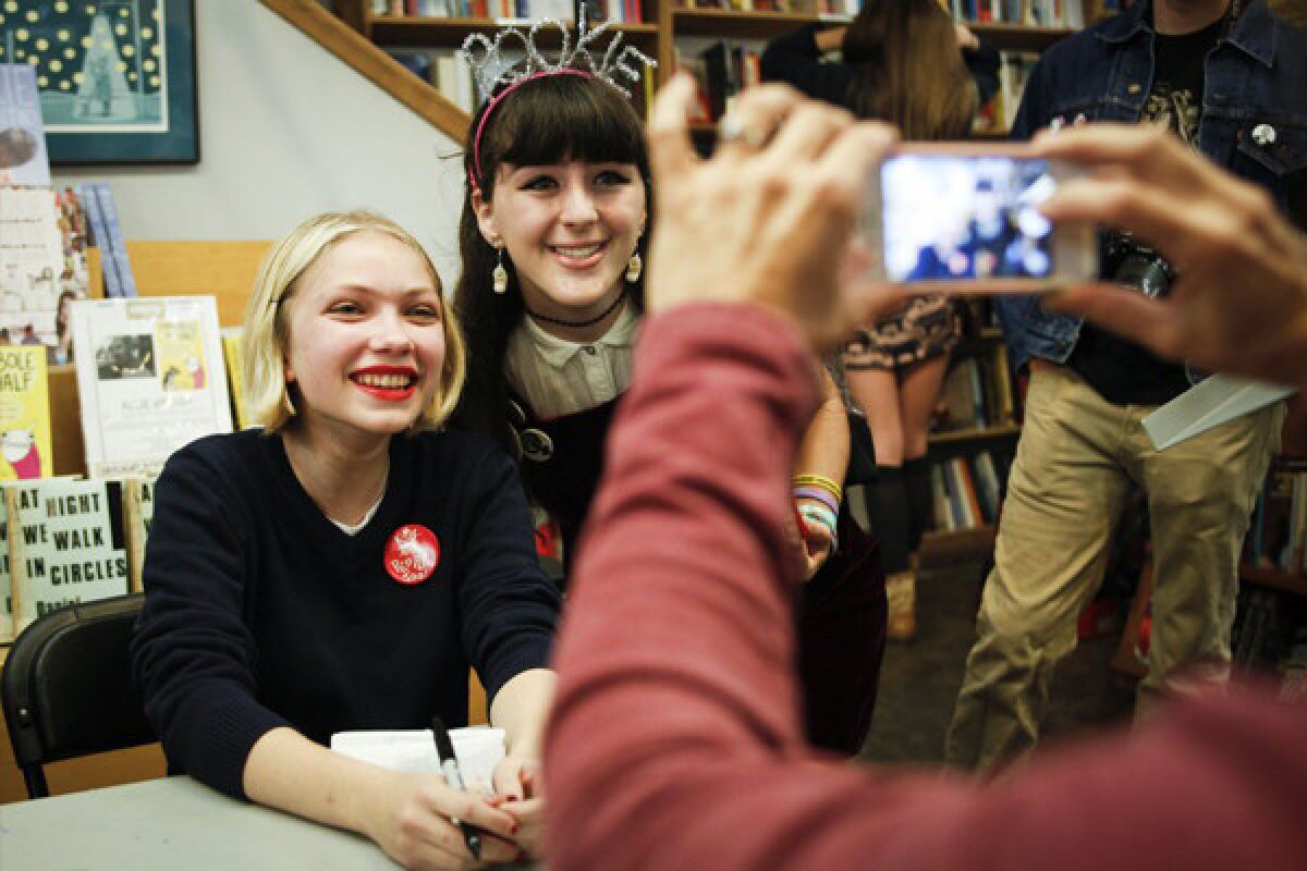 After a book signing and reading of "Rookie" magazine at Skylight Books in Los Angeles, Tavi Gevinson, left, pauses to snap a photo with reader Sarah Isenberg.