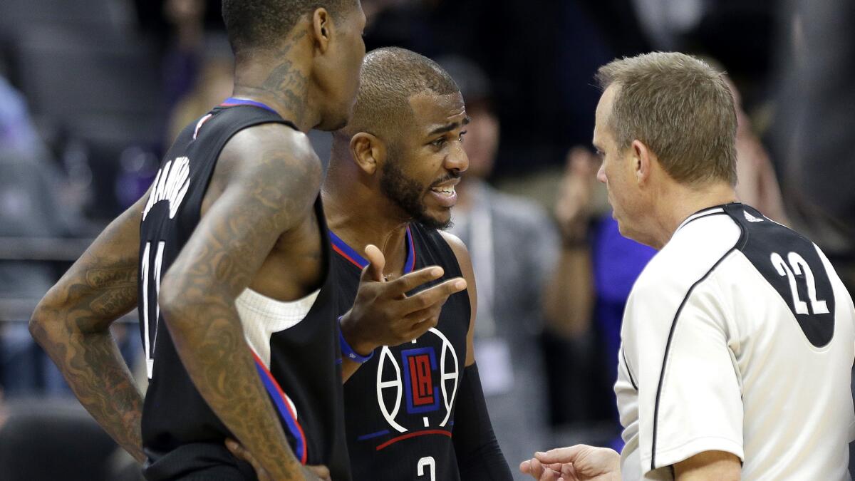 Clippers guards Chris Paul, center, and Jamal Crawford discuss a call with referee Bill Spooner during the second half against the Kings on Friday night in Sacramento.