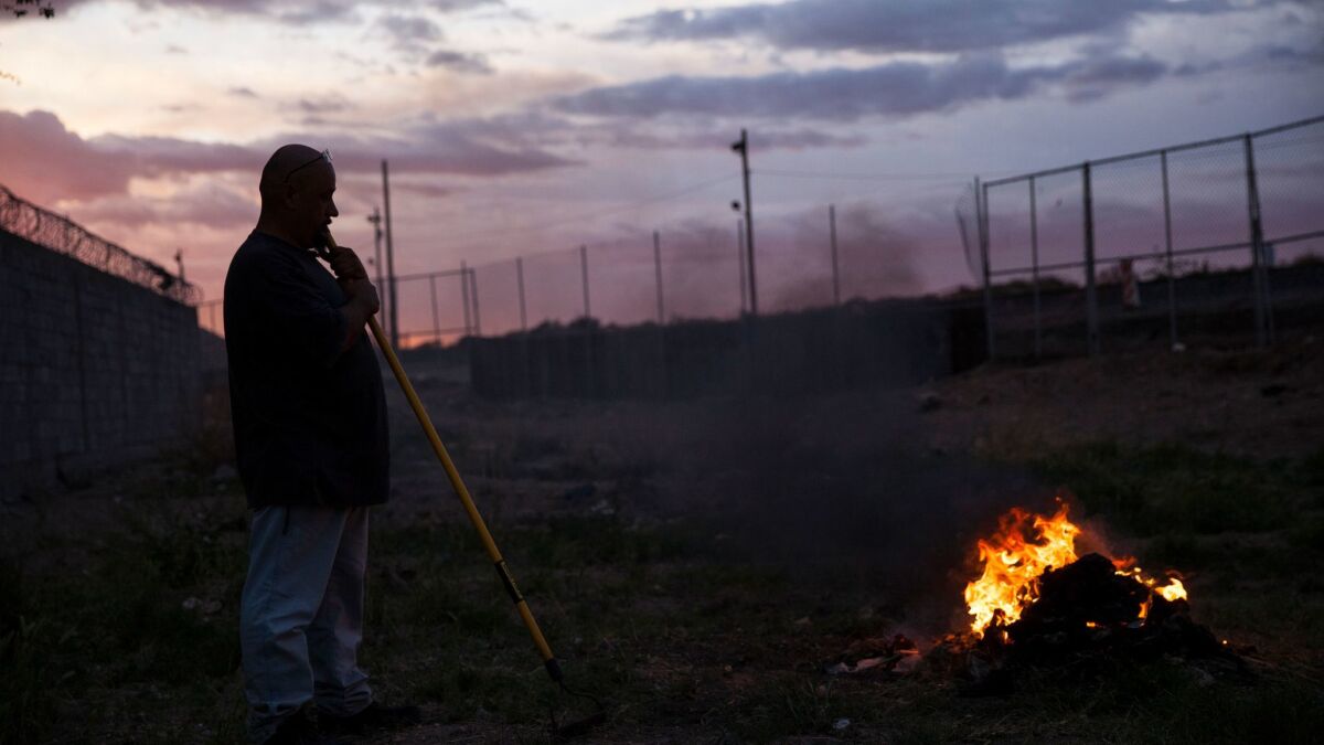 A man burns trash near the border fence in Ciudad Juarez, Mexico, last month.