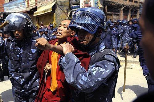 Police arrest a Tibetan protester in Katmandu, Nepal, on the 50th anniversary of the attempted uprising against China by the Tibetan people, which eventually led to the exile of the Dalai Lama.