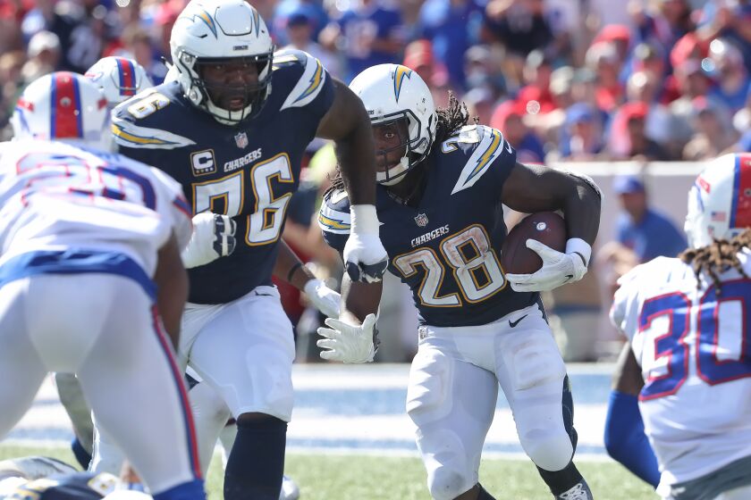 BUFFALO, NY - SEPTEMBER 16: Melvin Gordon III #28 of the Los Angeles Chargers carries the football as Russell Okung #76 blocks in front of him during NFL game action against the Buffalo Bills at New Era Field on September 16, 2018 in Buffalo, New York. (Photo by Tom Szczerbowski/Getty Images)