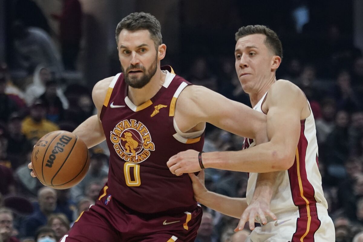 Cleveland Cavaliers' Kevin Love (0) drives against Miami Heat's Duncan Robinson (55) in the first half of an NBA basketball game, Monday, Dec. 13, 2021, in Cleveland. (AP Photo/Tony Dejak)
