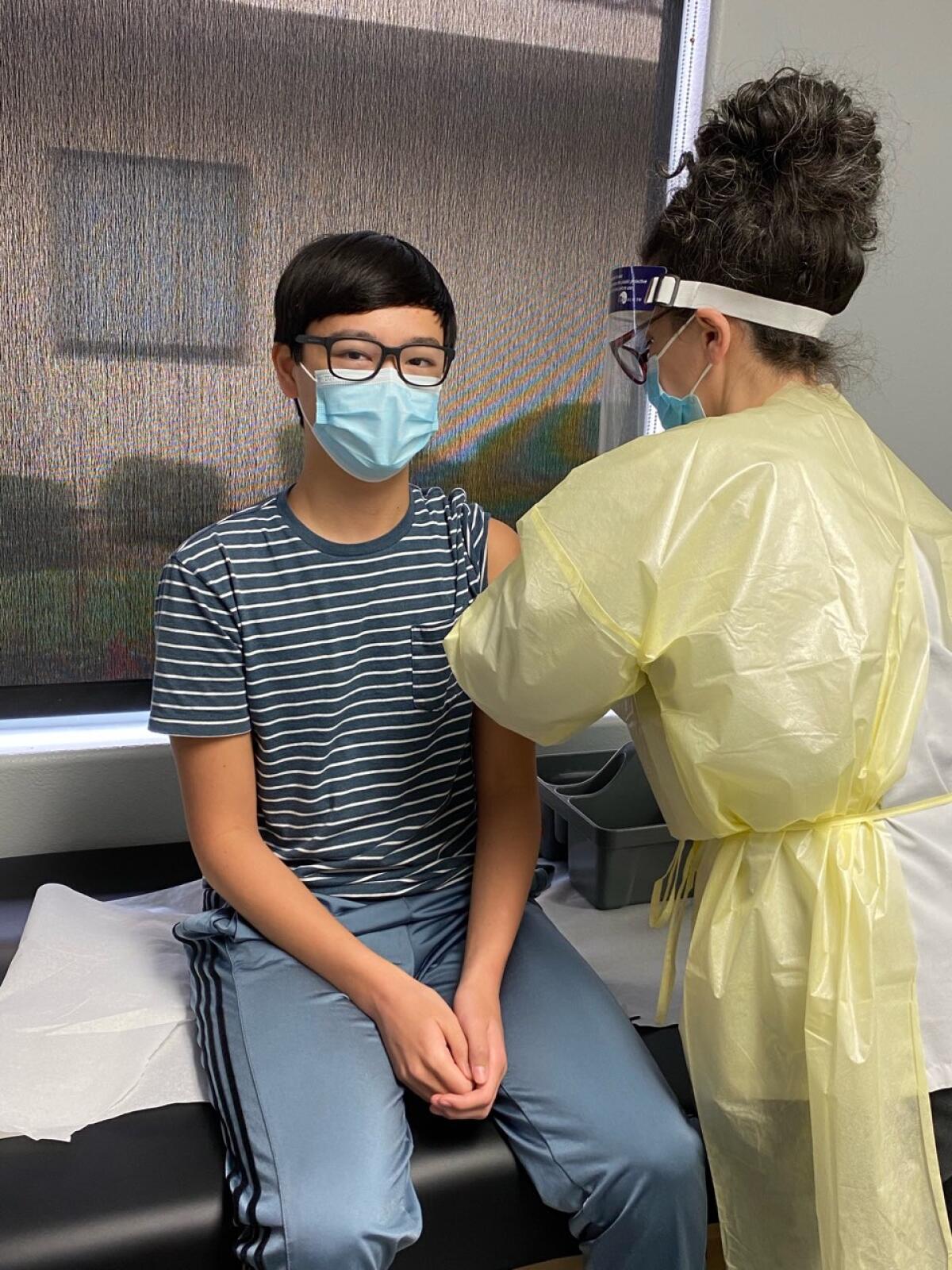 A teen boy receives an injection in the Moderna trial.
