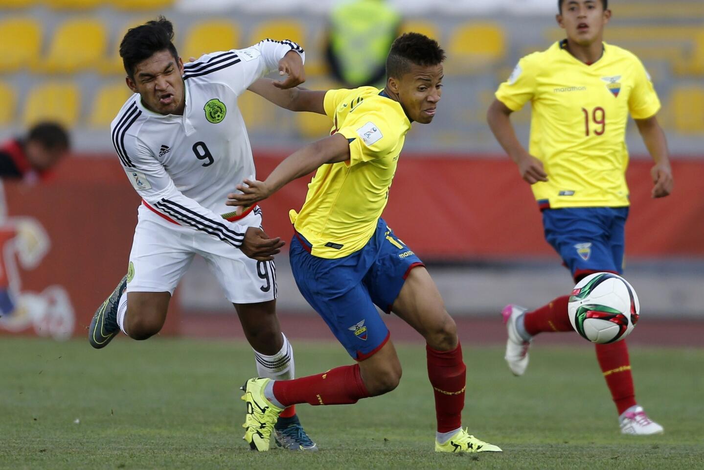 Ecuador's Byron Castillo (C) and Mexico's Eduardo Aguirre vie for the ball during their U-17 WC football match at the Francisco Sánchez Rumoroso stadium in Coquimbo, Chile, on November 2, 2015. AFP PHOTO/Andres Pina/PhotosportANDRES PINA/AFP/Getty Images ** OUTS - ELSENT, FPG, CM - OUTS * NM, PH, VA if sourced by CT, LA or MoD **