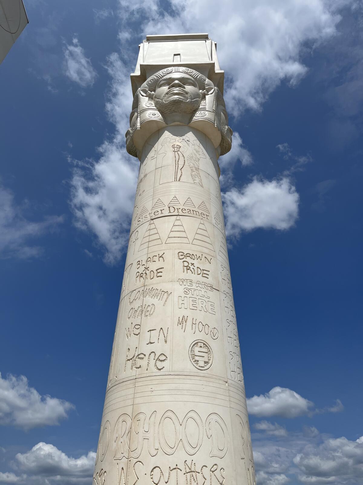 A view of an Egyptian-style column is ringed by carvings of the faces of Black people at the crown