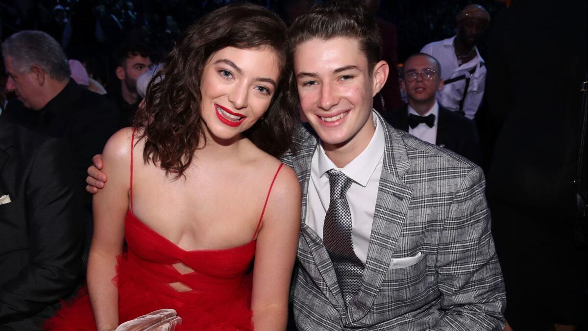 Lorde played up the color of her vibrant red Valentino gown, with a matching pout. Here she's with Angelo Yelich-O'Connor attending the 60th Grammy Awards in New York on Sunday.