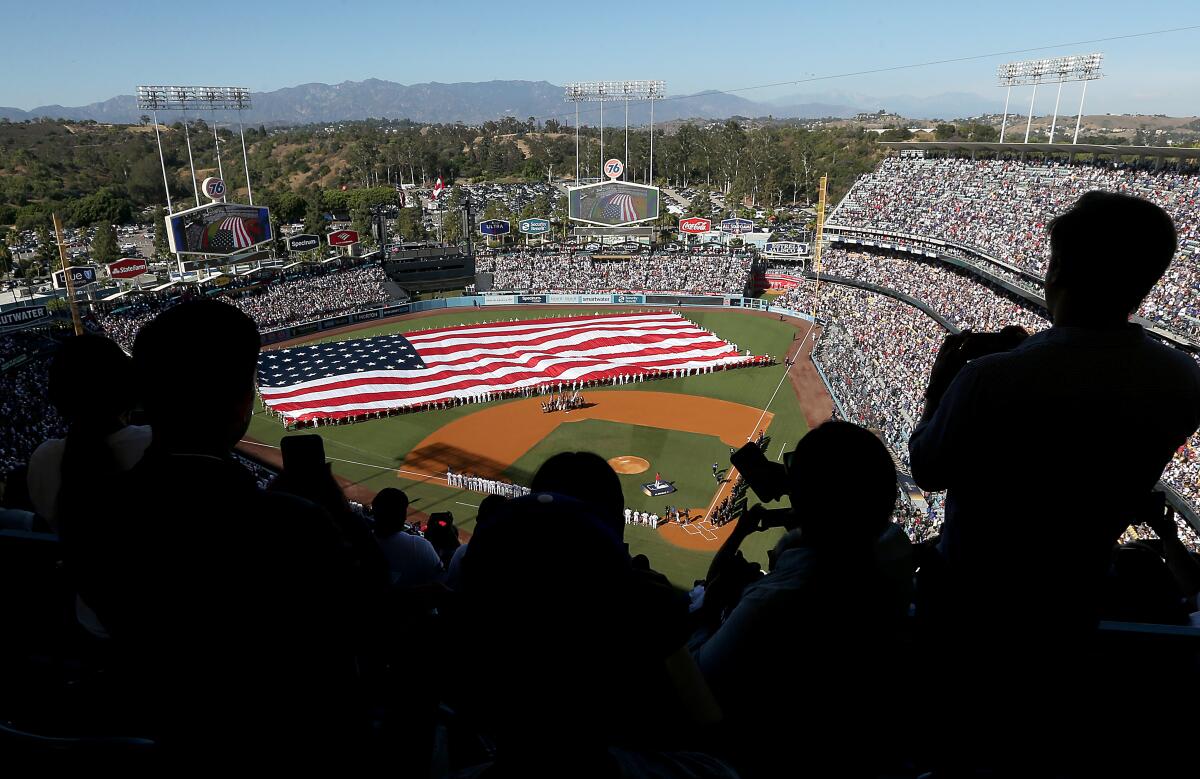 Fans stand during the national anthem before the start of 92nd MLB All-Star Game at Dodger Stadium on Tuesday.