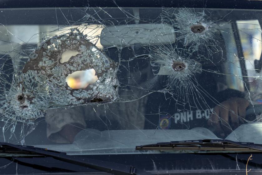 A police officer sits inside his vehicle with a windshield damaged by bullet holes, in Port-au-Prince, Haiti, Saturday, May 11, 2024. (AP Photo/Ramon Espinosa)