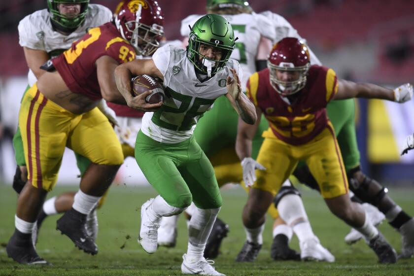 LOS ANGELES, CALIFORNIA - DECEMBER 18: Travis Dye #26 of the Oregon Ducks carries the ball for a first down.