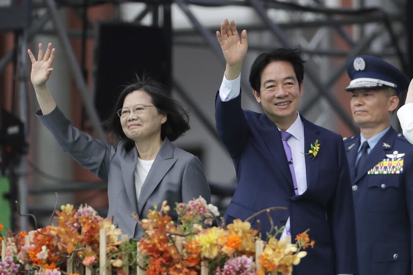 Taiwan's new President Lai Ching-te, right, and former President Tsai Ing-wen wave during Lai's inauguration ceremonies in Taipei, Taiwan, Monday, May 20, 2024. Lai in his inauguration speech has urged China to stop its military intimidation against the self-governed island Beijing claims as its own territory. (AP Photo/Chiang Ying-ying)