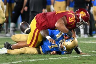 Pasadena, California November 19, 2022- UCLA quarterback Dorain Thompson-Robinson fumbles the ball while being sacked by USC's Tyronne Taleri in the third quarter at the Rose Bowl Saturday. (Wally Skalij/Los Angeles Times)
