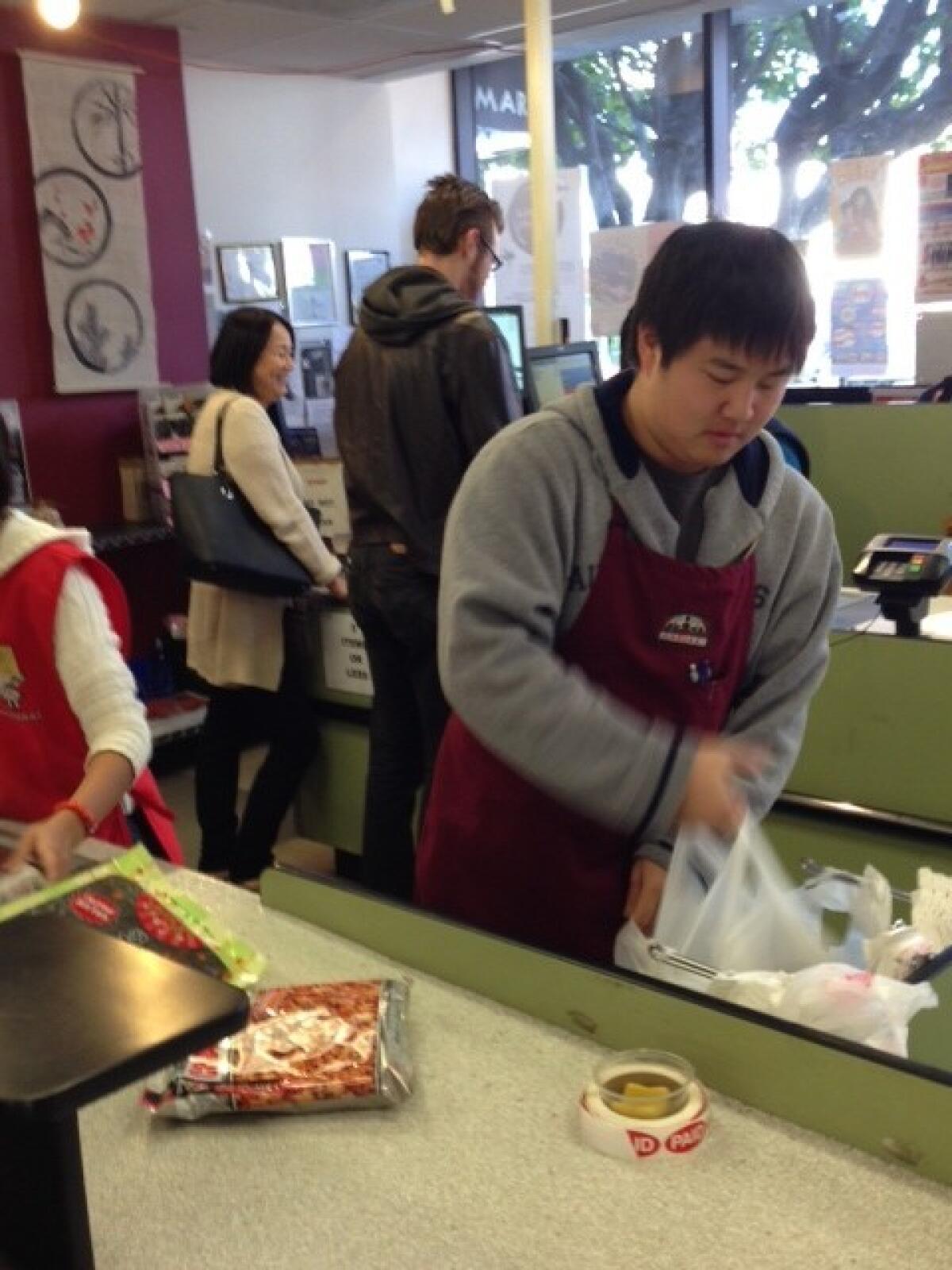Nicholas Ogino bags groceries at Marukai Market in Little Tokyo, which is posting signs about the coming change.