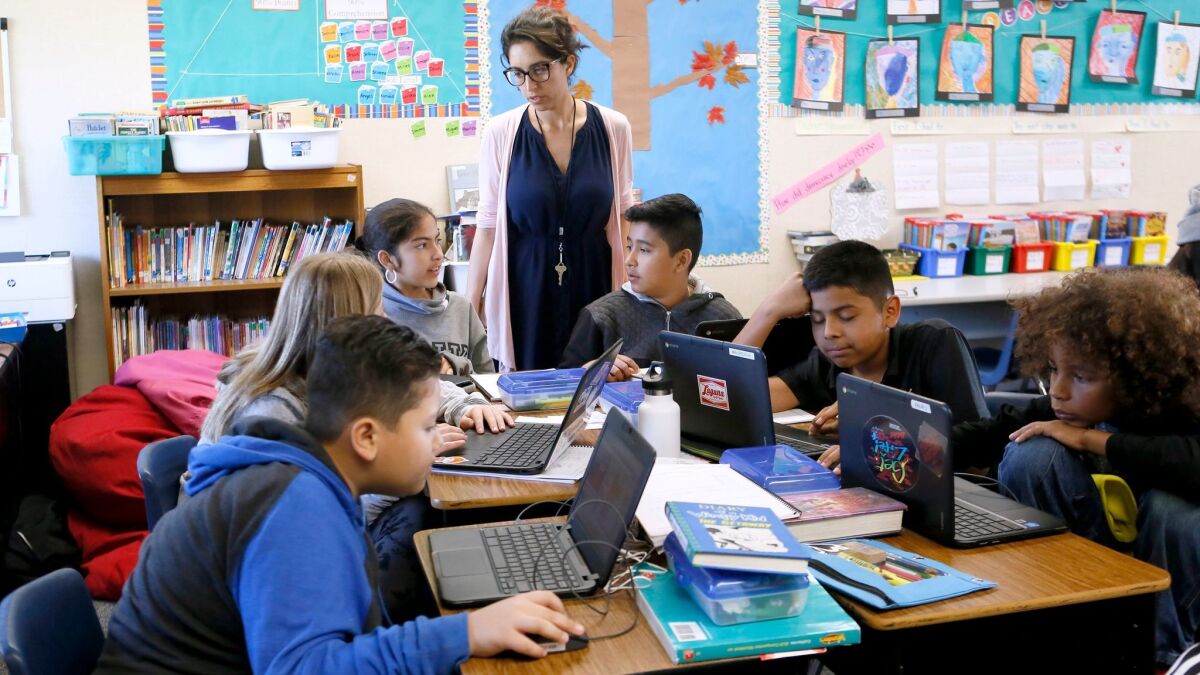 Adams Elementary School sixth-grade teacher Mahtab Spera talks to her students Friday during a weekly coding class.