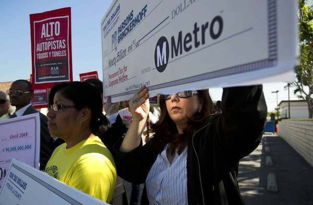 Rosa Miranda, left, of the Bus Riders Union, and Lisa Korbatov of Beverly Hills hold blank "checks" highlighting Measure J's corporate sponsors and beneficiaries during a news conference against the transit tax in Los Angeles in advance of the Nov. 6 election. The Coalition to Defeat Measure J included the Bus Riders Union, the Beverly Hills Unified School District and others.