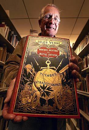 Curator George Slusser, 67 and now retired, holds an embossed publisher's edition of Jules Verne's "Mirifiques Aventures de Maitre Antifer." The book, printed in 1900, is part of the 110,000-volume Eaton collection at UC Riverside, the worlds largest library collection of science fiction, fantasy and horror books.