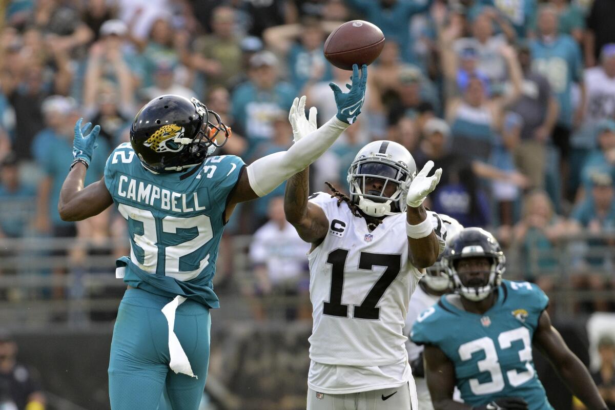 Jacksonville Jaguars cornerback Tyson Campbell (32) breaks up a pass intended for Las Vegas Raiders wide receiver Davante Adams (17) in the second half of an NFL football game Sunday, Nov. 6, 2022, in Jacksonville, Fla. (AP Photo/Phelan M. Ebenhack)
