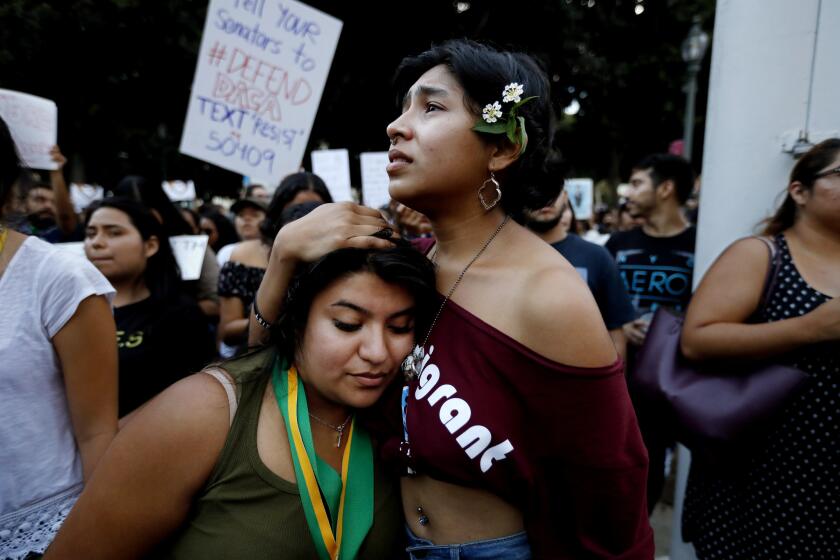 Victoria Sandoval, 22, left, of Los Angeles, a DACA recipient, is consoled by sister Maria Sandoval, 20, a U.S. citizen, while protesters gathered at City Hall to demonstrate against changes in the Deferred Action for Childhood Arrivals program.