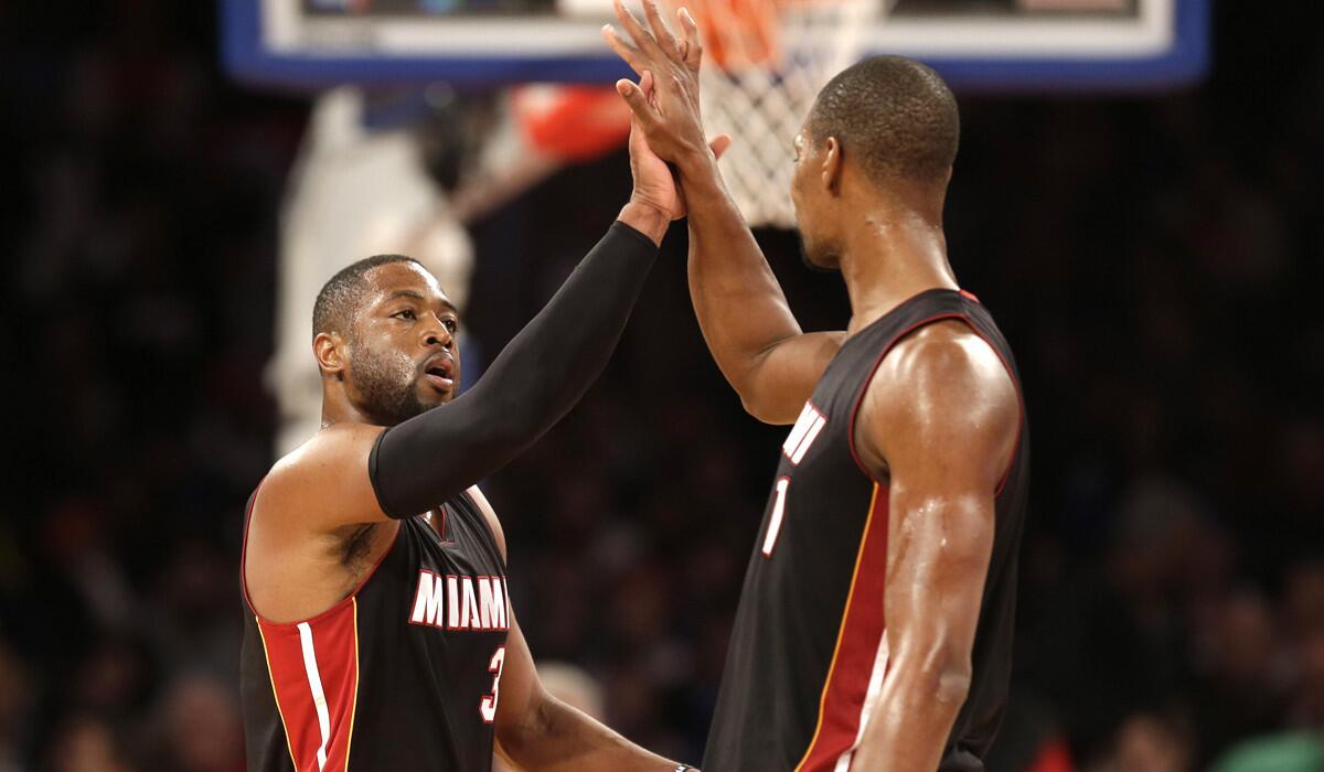 Heat guard Dwyane Wade, left, celebrates with forward Chris Bosh during the second half of their 86-79 victory over the Knicks on Sunday in New York.