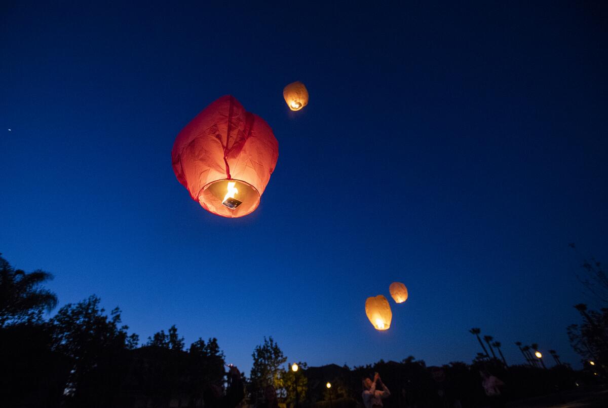 Sky lanterns rise into the night air Tuesday during a surprise 16th-birthday celebration for Madison Moore of Huntington Beach.