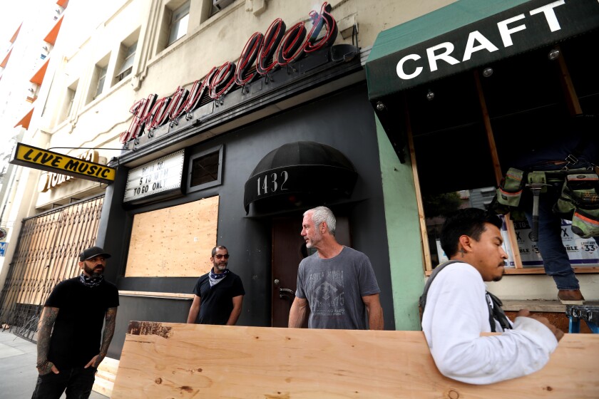 Jason Gochin, from left, Damian Anastasio and Cevin Clark, co-owners of Harvelle’s, stand in front of their place in Santa Monica.