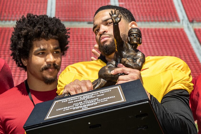 Los Angeles, CA - April 15: 2022 Former USC running back Travis Dye left, watches Heisman winner Caleb Williams.