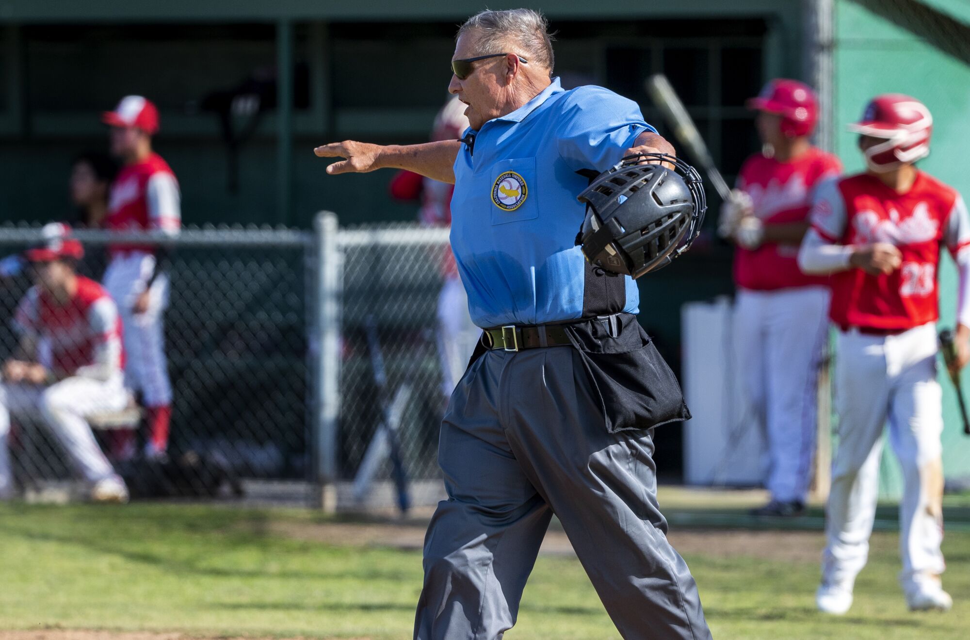 Umpire Jim Trentin lifts his arms during a game.