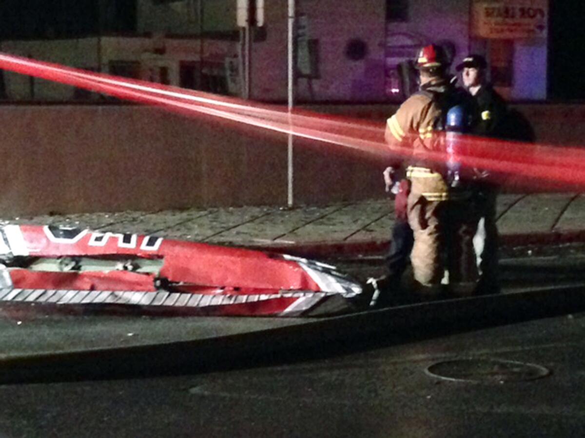 Firefighters stand near a piece of wreckage after a small plane slammed into a commercial building in downtown Anchorage early Tuesday.