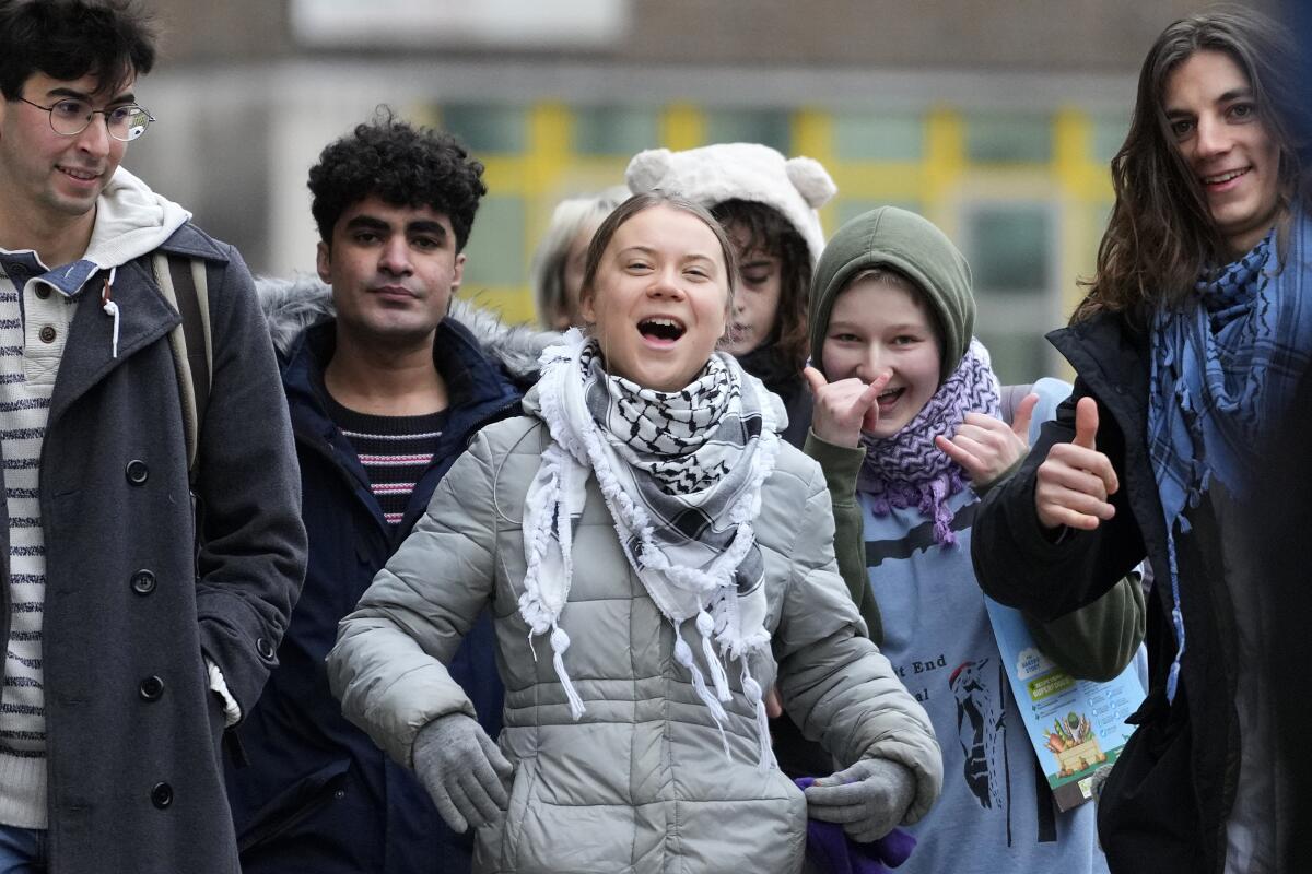 Greta Thunberg, center, arrives with other protesters at court in London