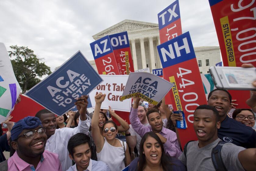 Demonstrators cheer as they hold up signs outside the Supreme Court after the court ruled that the Affordable Care Act may provide nationwide tax subsidies on June 25.