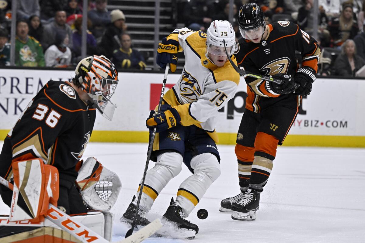 Ducks goalie John Gibson tracks the puck along with teammate Troy Terry, right, and Nashville's Juuso Parssinen.