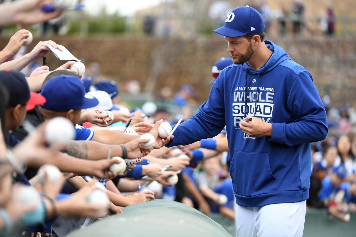 Clayton Kershaw #22 of the Los Angeles Dodgers signs autographs prior to a spring training game against the San Francisco Giants at Camelback Ranch on March 11, 2019 in Glendale, Arizona.