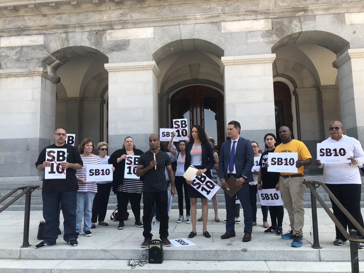 More than a dozen protesters gather at the state Capitol to speak out against bail overhaul bill.