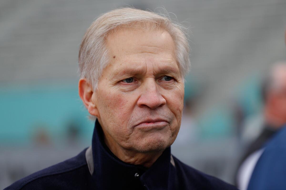 ESPN football analyst Chris Mortensen stands on the sideline during an Alliance of American Football game.
