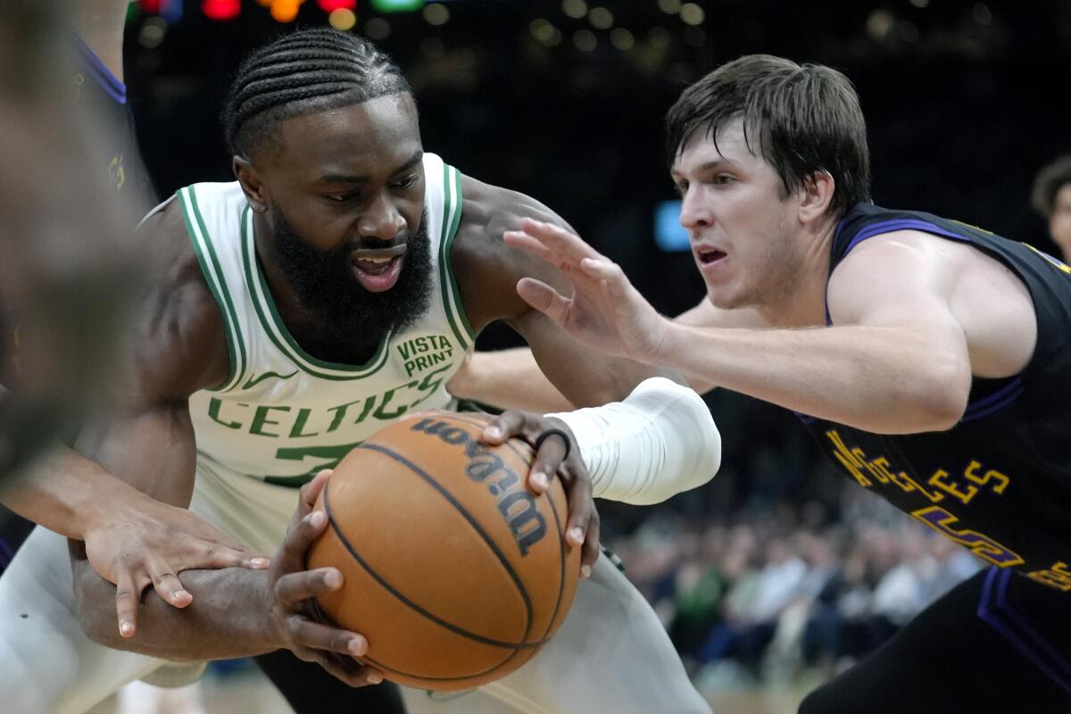Lakers guard Austin Reaves, right, plays tight defense against Celtics guard Jaylen Brown, who tries to control the ball.