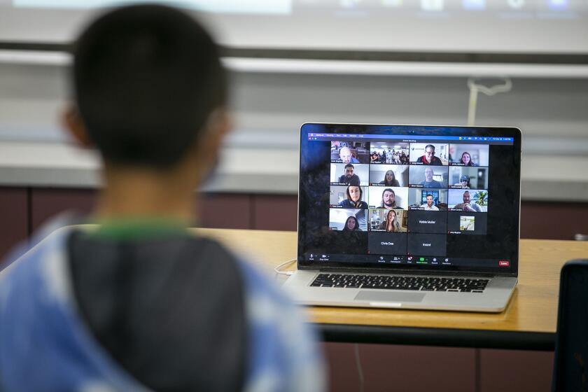 A student in Amy Meunier Bogdon's fourth-grade class at Victoria Elementary in Costa Mesa interacts with executives at Veritone, a company which specializes in artificial intelligence, on Friday, October 22.