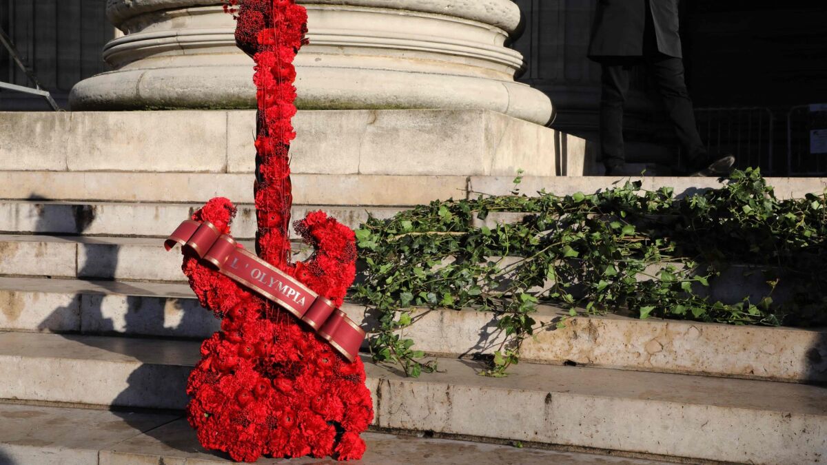 A guitar-shaped floral wreath featuring the name of one of Paris' iconic music hall venues "L'Olympia," stands outside the Catholic Church of La Madeleine before the funeral for Johnny Hallyday.
