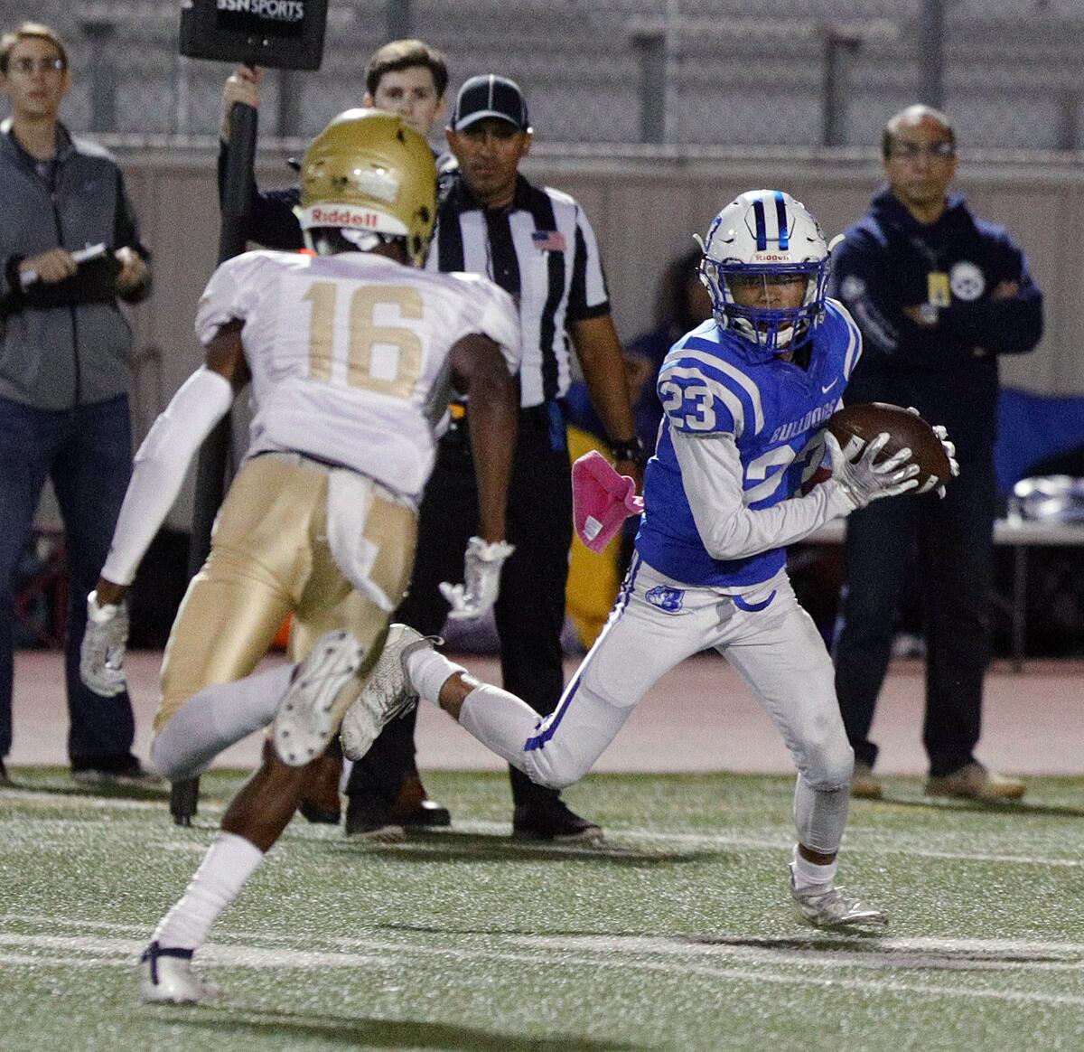 Burbank's Kaze Gibbs, after catching a screen pass, turns to face Muir's Asa Roberson in a Pacific League football game at Burroughs High School on Monday, October 14, 2019.