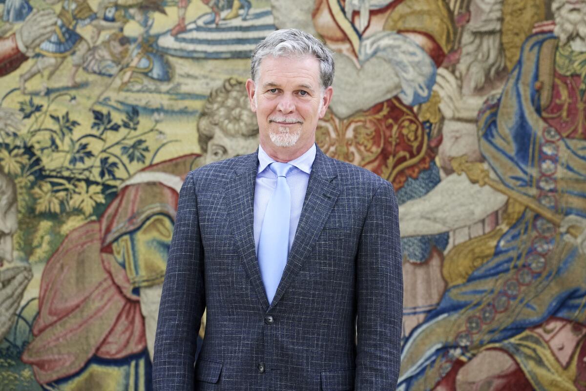 A man in front of colorful piece of wall art.