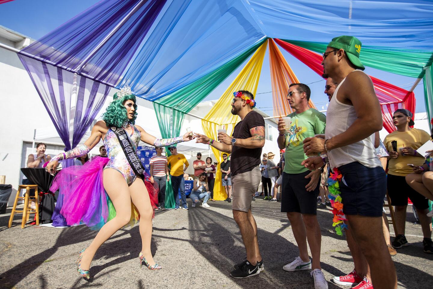 Alex Paz, right, gives Nomi B a tip during a performance at the the Laguna Beach Pride celebration on Saturday , June 2.
