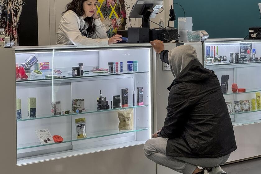 Alex Silecchia, left, a marijuana "budtender," also known as a sales associate, serves a customer at States Cannabis Company dispensary, Friday, Sept. 29, 2023, in New York. New York is set to dramatically expand its legal weed market and issue over 1,000 new licenses starting early next year, to include deep-pocketed marijuana companies. (AP Photo/Ayesha Mir)