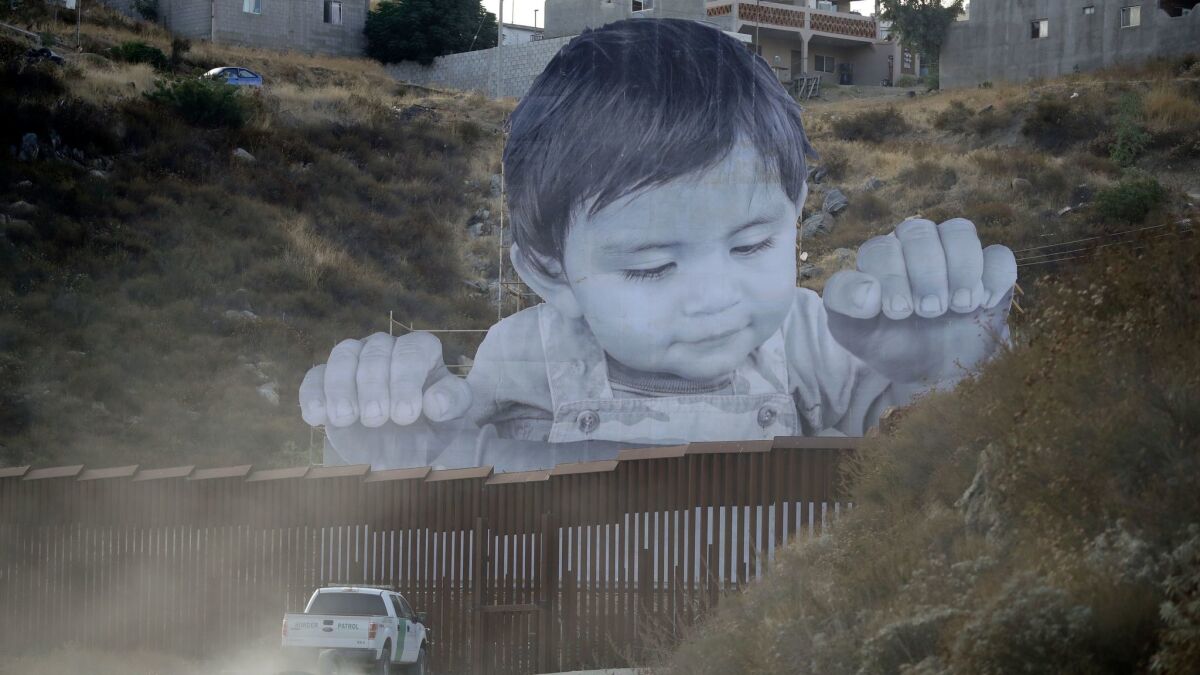 A French artist aiming to prompt discussions about immigration erected a 65-foot-tall cutout photo of a Mexican boy, pasting it to scaffolding built in Mexico.