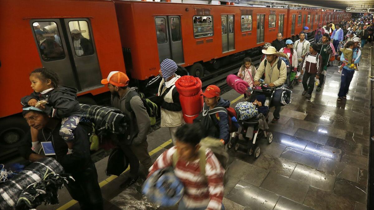 Central American migrants wait to board the subway after leaving a temporary shelter Nov. 10 at the Jesus Martinez Stadium in Mexico City.