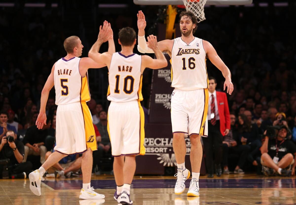 Lakers teammates Steve Blake, left, Steve Nash and Pau Gasol celebrate a basket during the first half of Sunday's game against the Atlanta Hawks at Staples Center.