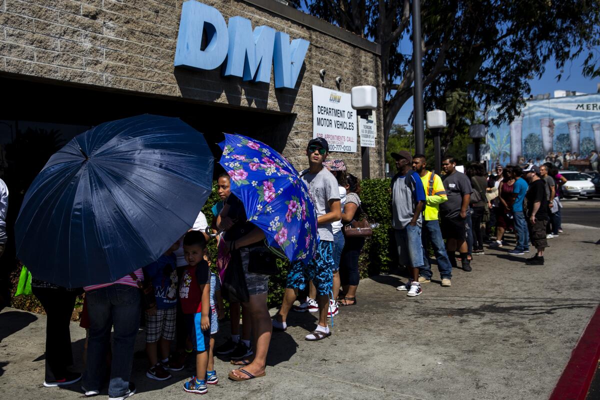 People wait in line outside a DMV office in South Los Angeles in 2018. 
