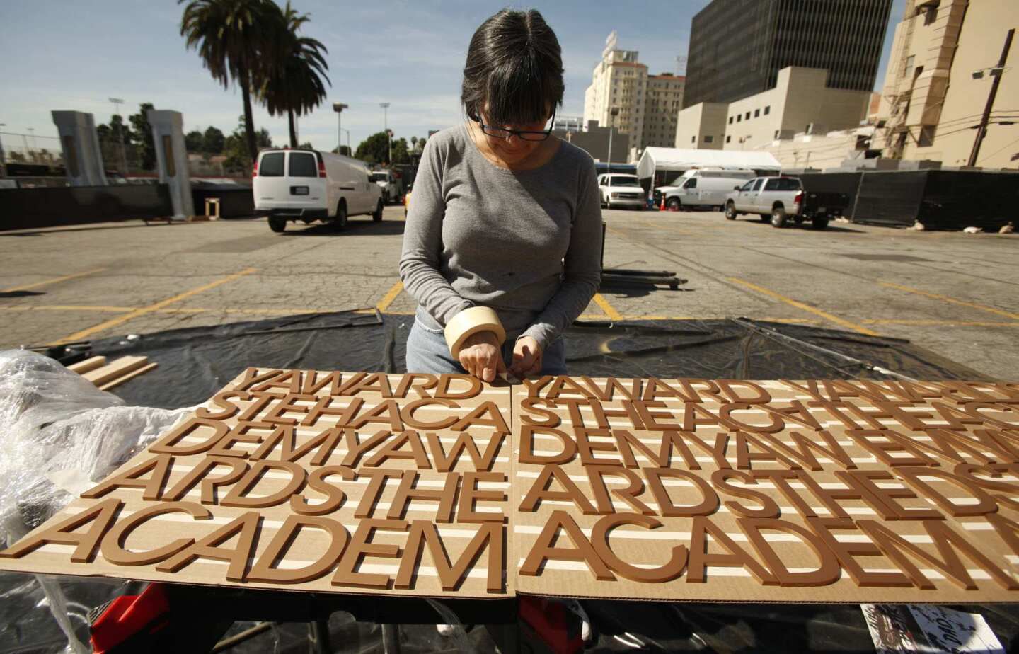 Scenic artist Virginia Bellini works on scenery as preparations continue on Hollywood Boulevard.