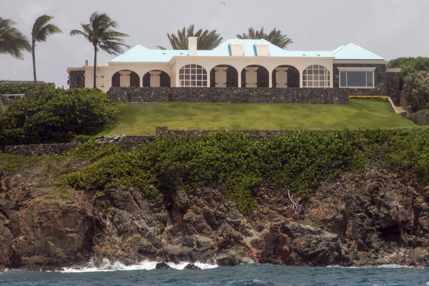 This Tuesday, July 9, 2019 photo shows a structure on Little Saint James Island, in the U. S. Virgin Islands. Locals recalled seeing Jeffery Epstein's black helicopter flying back and forth from the international airport in St. Thomas to his helipad on Little St. James Island, where he built a cream colored mansion with a bright turquoise roof surrounded by several other structures including the maids' quarters and a massive, square-shaped white building on one end of the island that some say is a music room fitted with acoustic walls. (AP Photo/Gianfranco Gaglione)