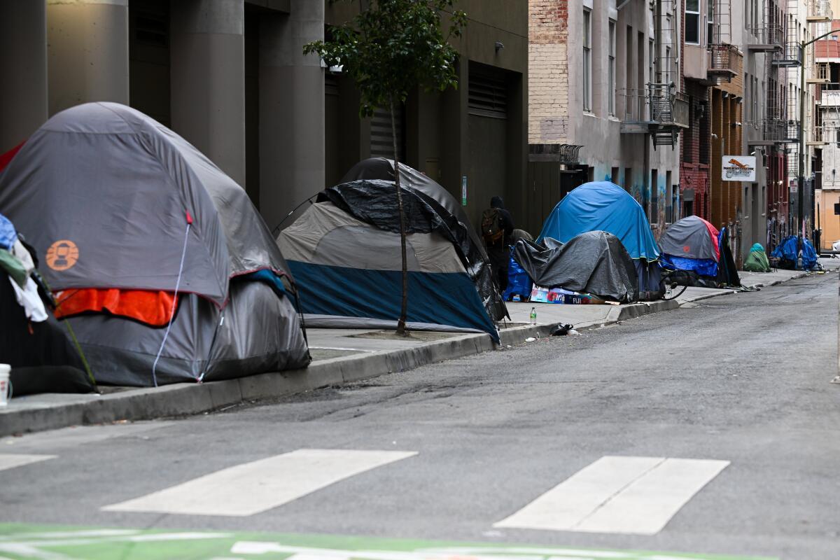 A row of tents on a sidewalk of a city street